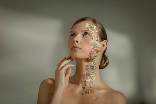 Woman face covered with flower petals