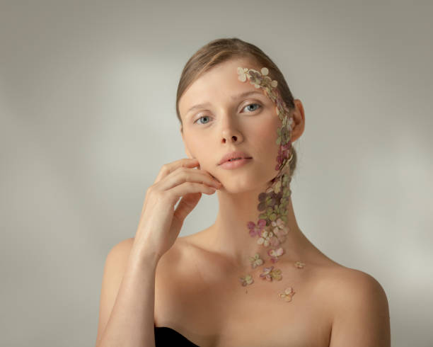istock Woman face covered with flower petals 1443893591