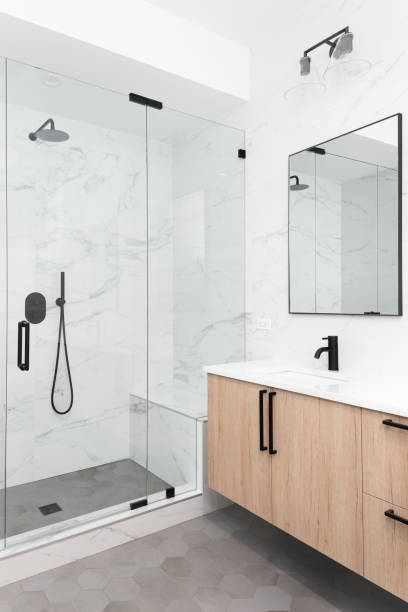 istock A bathroom with a wood vanity and a marble walk-in shower. 1443896345