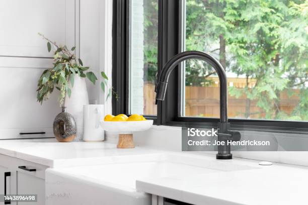 A Black Faucet Detail Shot With A White Farmhouse Sink Stock Photo - Download Image Now