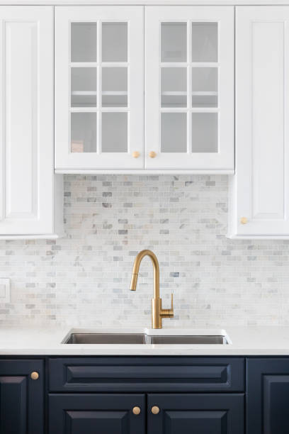 istock A gold faucet in a white and blue kitchen. 1443896501