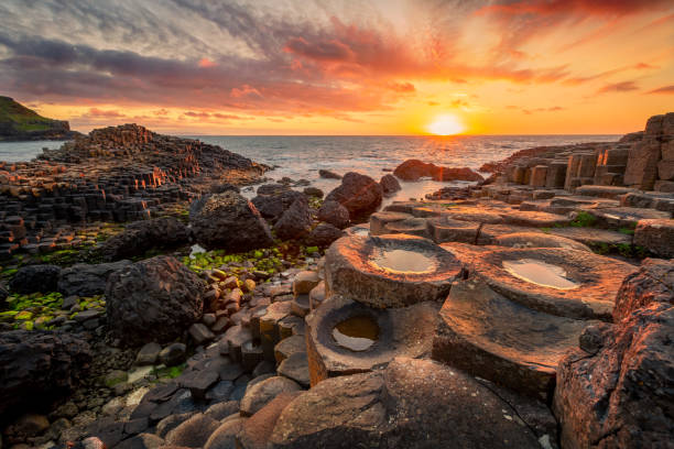 sunset over basalt columns Giant's Causeway, County Antrim, Northern Ireland sunset over basalt columns Giant's Causeway known as UNESCO World Heritage Site, County Antrim, Northern Ireland giants causeway stock pictures, royalty-free photos & images