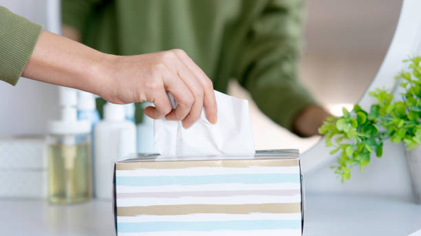 women hand picking napkin tissue paper from the tissue box stock photo