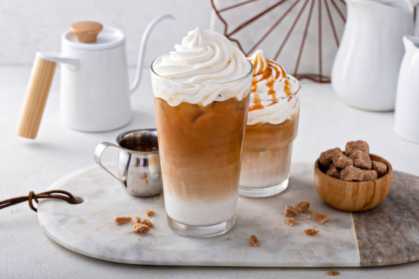 Iced caramel latte topped with whipped cream and caramel sauce stock photo