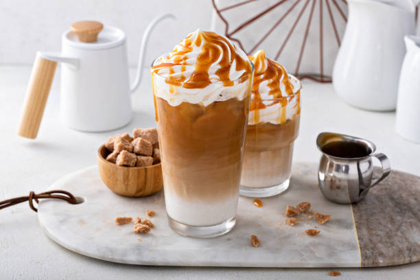Iced caramel latte topped with whipped cream and caramel sauce Iced caramel latte topped with whipped cream and caramel sauce, refreshing and sweet coffee drink latte stock pictures, royalty-free photos & images