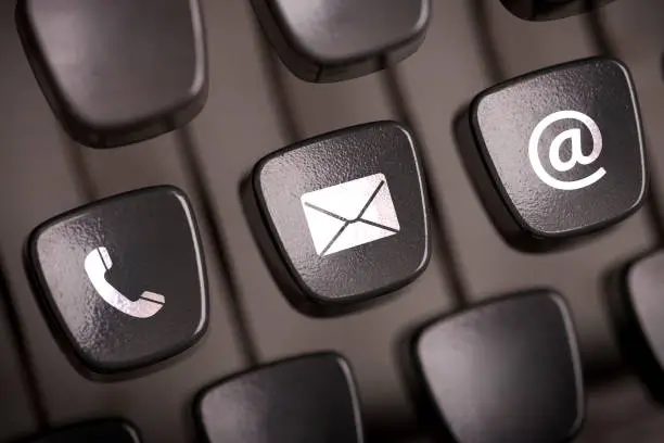 Contact us concept. Email, mail and telephone icons on typewriter keypad.
