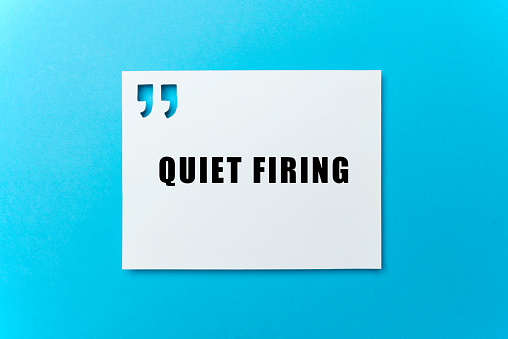 Quiet Firing text on white card on blue background.