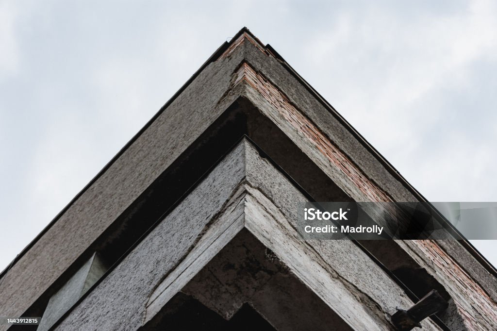 Old building corner Old soviet building balcony with parts falling from it. Degraded building became obsolete Abandoned Stock Photo