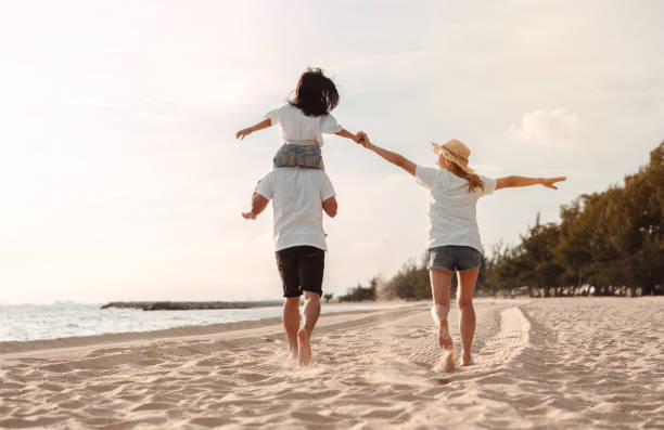 Happy asian family enjoy the sea beach at consisting father, mother and daughter having fun playing beach in summer vacation on the ocean beach. Happy family with vacations time lifestyle concept. la familia asiática feliz disfruta de la playa del mar en la que consisten padre, madre e hija divirtiéndose jugando a la playa en las vacaciones de verano en la playa del océano. familia feliz con concepto de estilo de vida de tiempo de vacaciones.