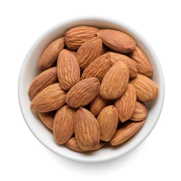 istock Almond nuts in white bowl isolated on white. Top view. 1443915506