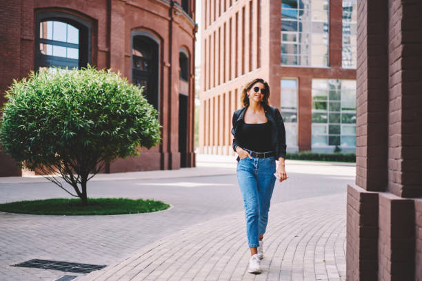 istock Cheerful young woman walking on sidewalk 1443915844