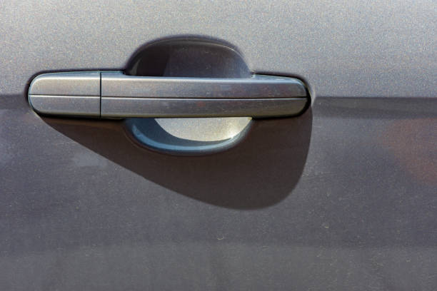 Close up to a metallic gray car door handle stock photo