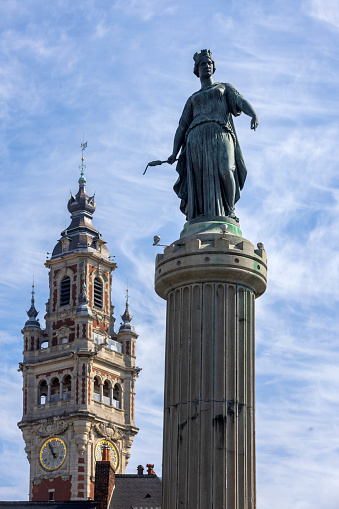 Memorial of the Siege of 1792 on Grand Place in the city center of Lille with the tower of the Chamber of Commerce on the Place du Théâtre in the background. The citizens of Lille gave the memorial the popular name Column of the Goddess; Lille, France