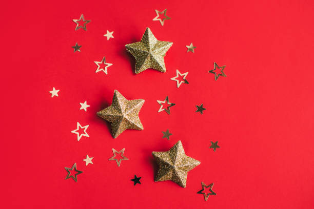 istock Golden sparkling stars on a red background. Flat lay. 1443922040