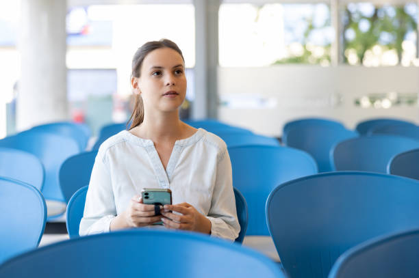 mulher na sala de espera do hospital segurando seu telefone celular - registry office - fotografias e filmes do acervo