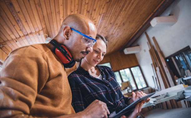 istock Couple of young carpenter working together 1443936537