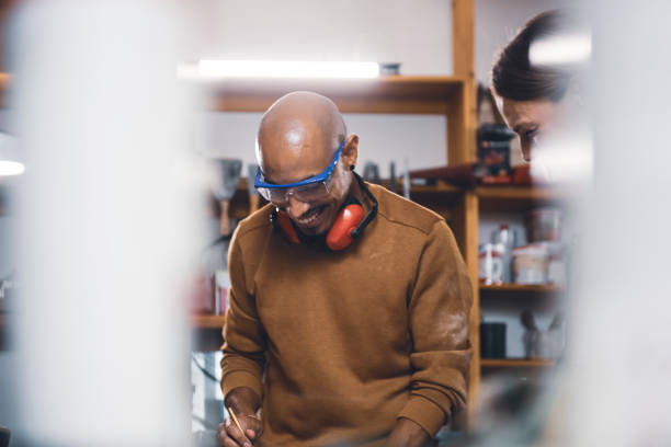 istock Couple of young carpenter working together 1443936542