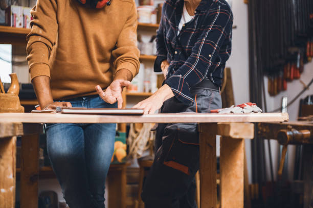 istock Couple of young carpenter working together 1443936553