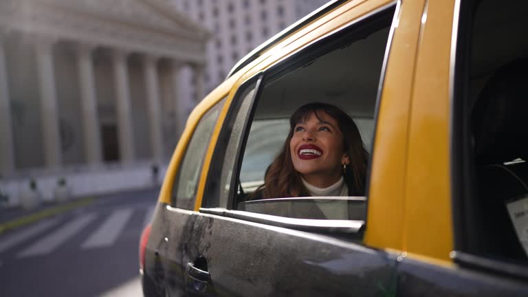 Young woman admiring the city inside the taxi