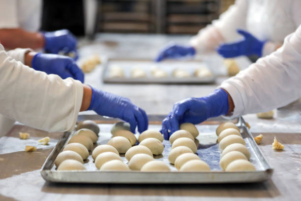 istock Teamwork in the Kitchen, Rolling the Dough, Preparation of Bakery Products 1443942072