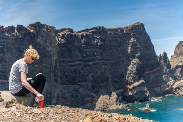 hiker resting on the edge of the cliff - hiking coastline waters edge sunny imagens e fotografias de stock