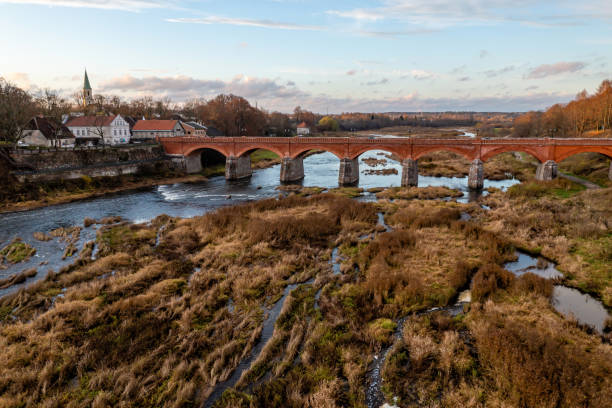istock Venta Rapid waterfall, the widest waterfall in Europe and long brick bridge 1443947397