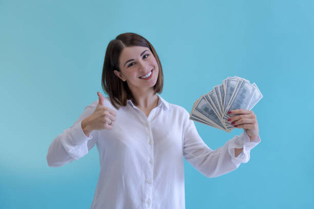 istock Woman holds stack of money 1443947987