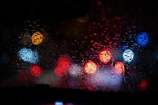 View of traffic from inside the car on a rainy evening.