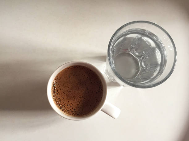 Turkish coffee and glass of drinking water on the white tray stock photo