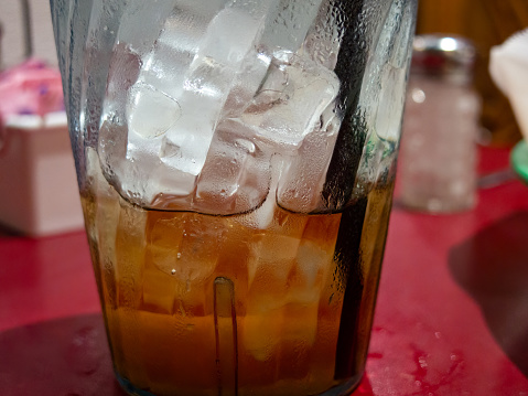Partially consumed glass of iced tea condensing at a restaurant