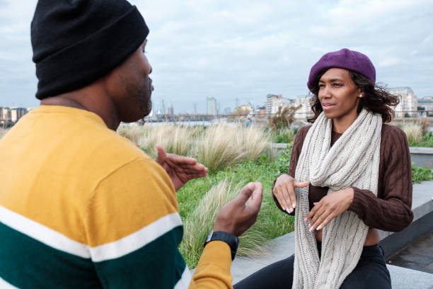 istock Two deaf friends are talking using sign language outdoors. 1443955136
