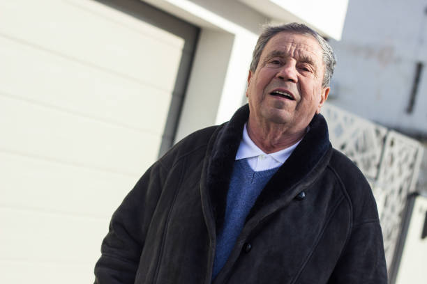 istock Cheerful senior man in front of house 1443957063