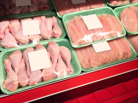 Chicken meats. Packages of refrigerated chicken legs and chicken breasts in supermarket