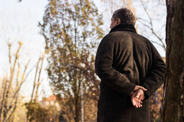 istock Pensive senior man walking at park 1443957354