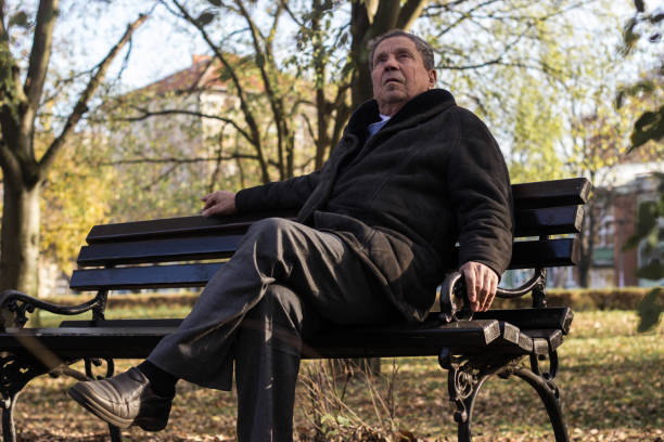 istock Lonely senior man sitting on bench 1443957512