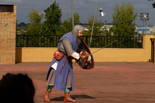 un uomo vestito in abiti medievali si prepara a simulare un combattimento - history knight historical reenactment military foto e immagini stock