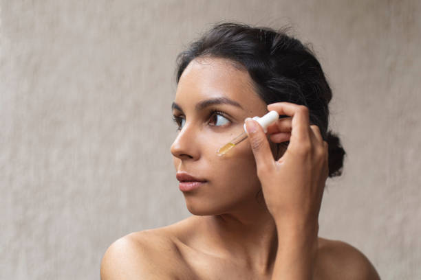 istock Young woman applying face oil 1443957952
