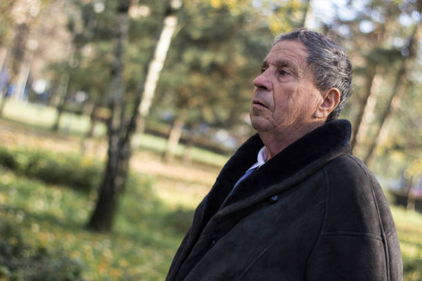 istock Pensive senior man walking at park 1443958279