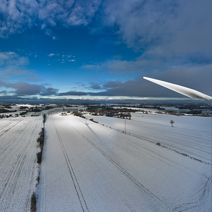 Landscape with new fallen snow. Wind turbine close-up on pause. Shadow of wind mill