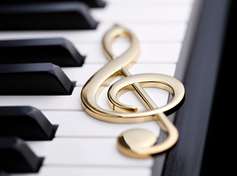 Golden treble clef on piano keyboard with copy space