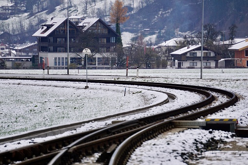 Roter Zug im Winter in den Alpen. Zillertal Zug im Winter. Der Zug fährt im Winter den Bogen entlang. Ein roter Zug fährt einen Bogen entlang einer schneebedeckten Eisenbahn.