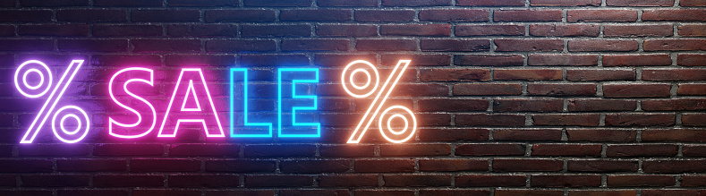 Sale concept. Neon lighting sale word and percentage signs on the brick wall with copy space