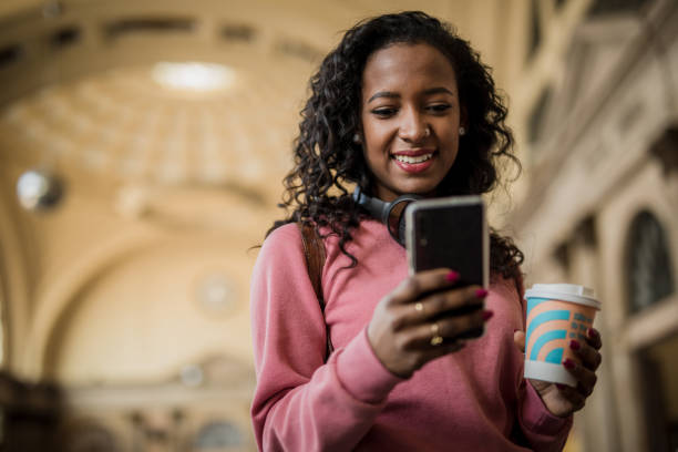 istock Young hipster black woman using smartphone at train station while waiting for her train 1443966361