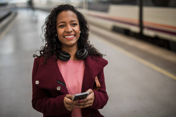 istock Young hipster black woman using smartphone at train station while waiting for her train 1443966387