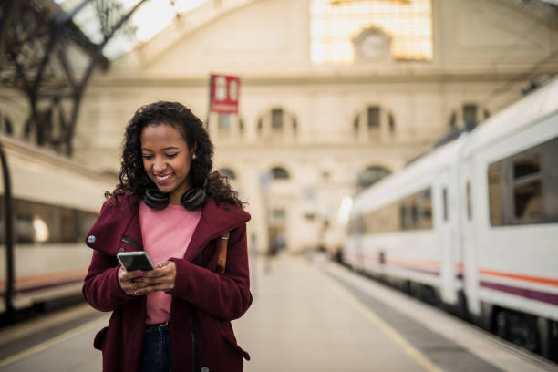 istock Young hipster black woman using smartphone at train station while waiting for her train 1443966417