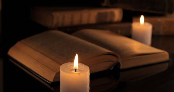istock An old book and burning candles 1443967972