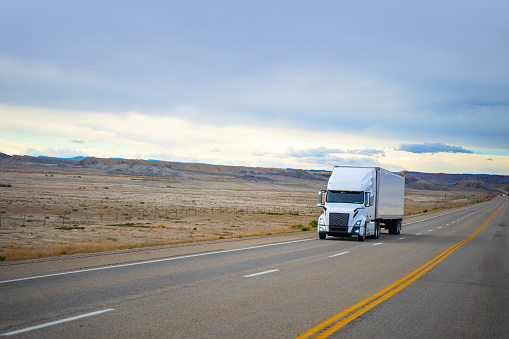 White Semi-truck driving in Utah, USA