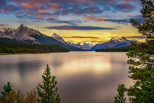 Sunset over Maligne Lake in Jasper National Park, Canada, with snow-covered peaks of canadian Rocky Mountains in the background. Long exposure.