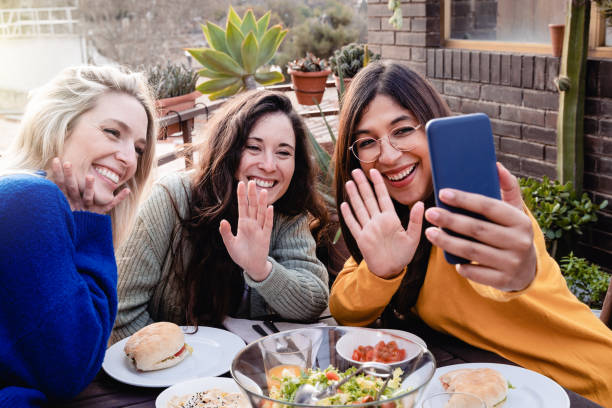 istock Happy multiracial friends using mobile phone at backyard vegan dinner party - Focus on center girl face 1443976238