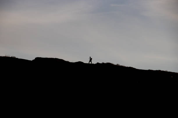istock Silhouette of guy climbing mountain in Pacifica 1443977572